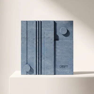 Minimalist bir sergi kaidesi üzerinde duran, Girift markasına ait brütalist ve geometrik beton duvar aksesuarı.